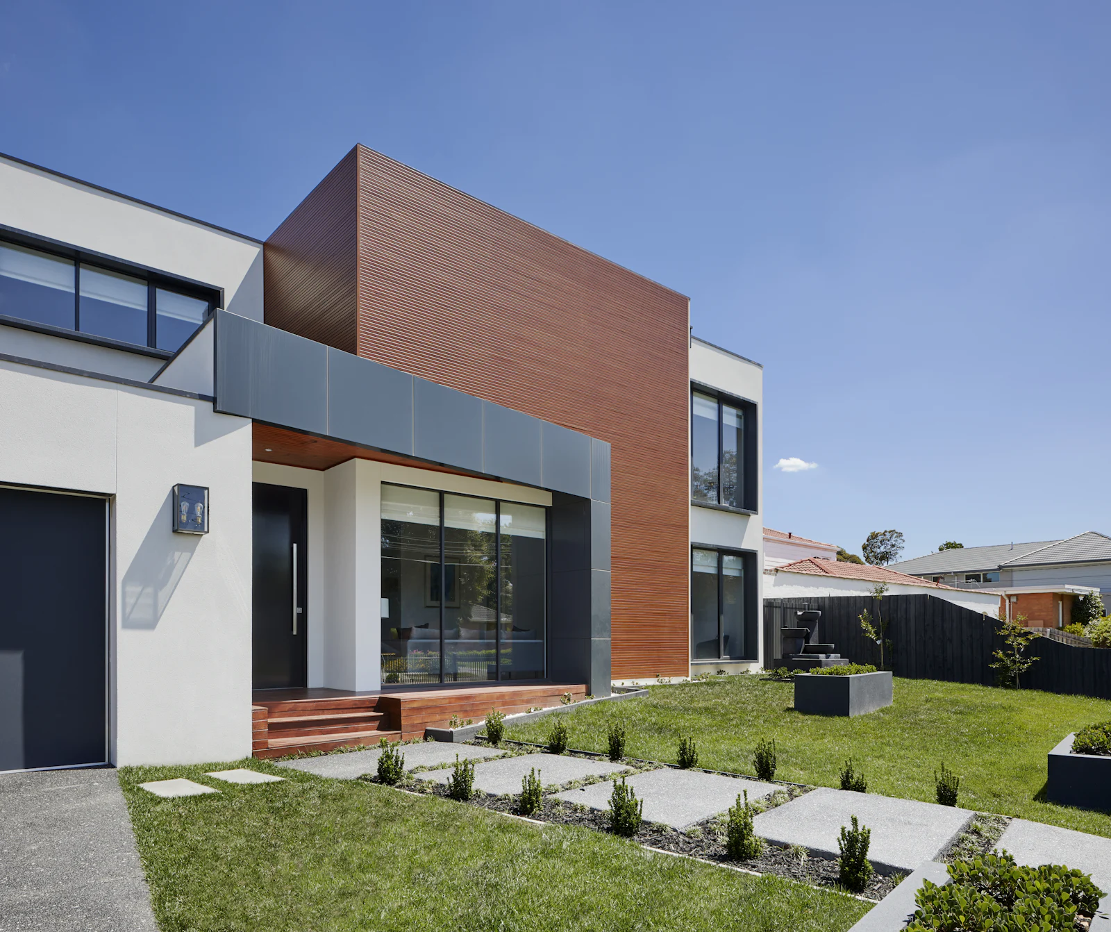 Modern bungalow with rendered walls and a timber-clad feature volume