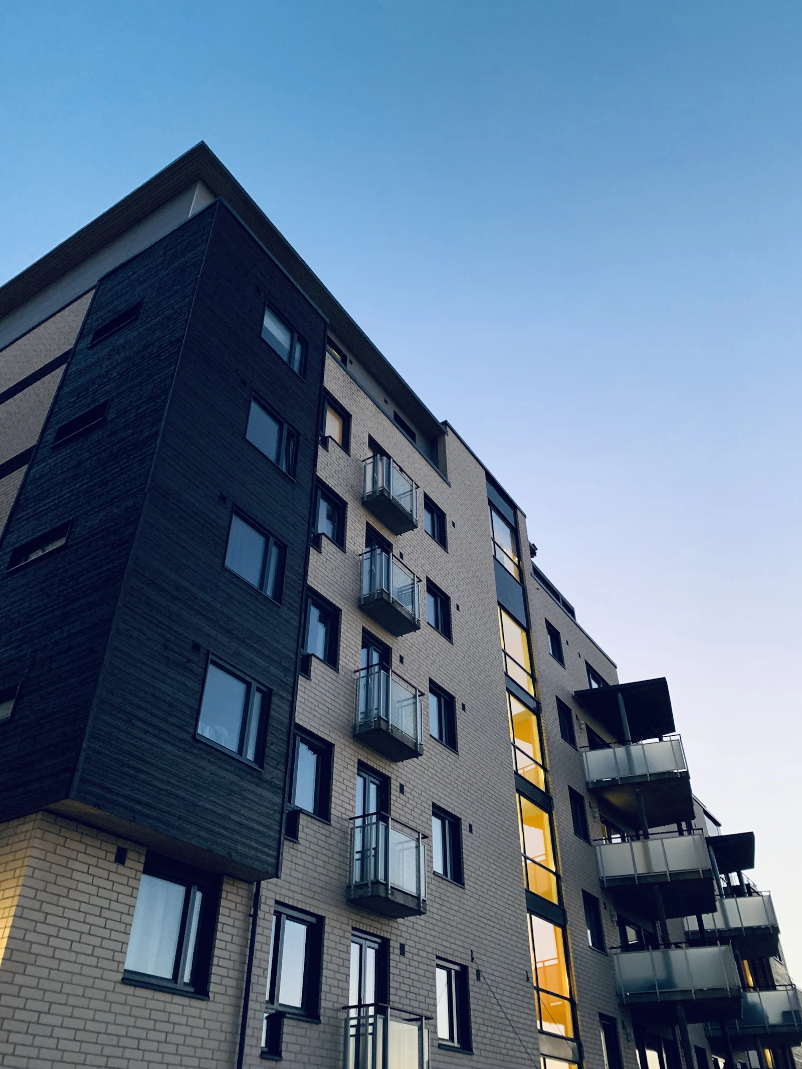 Modern apartment building with balconies and a dark clad façade