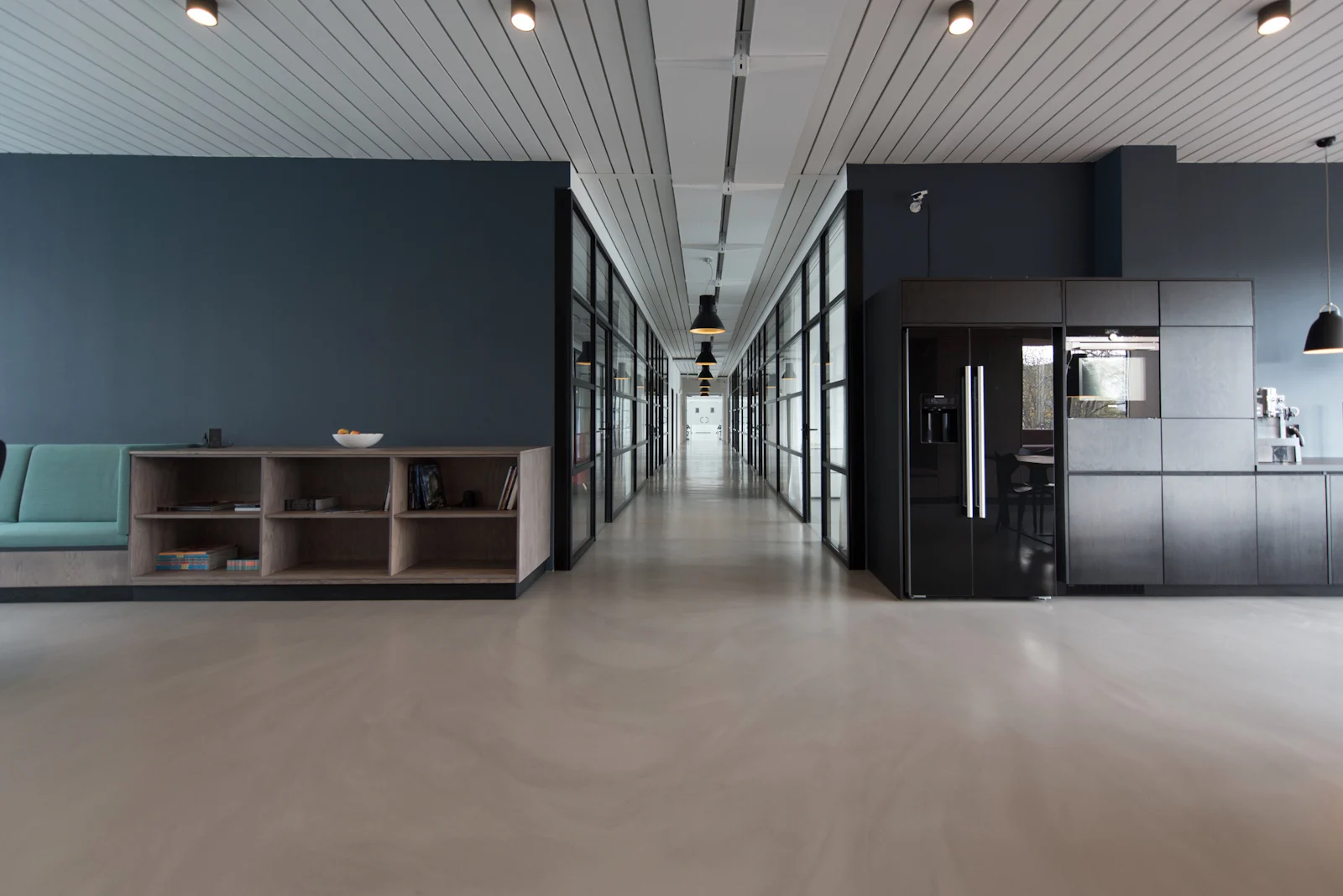 Clean commercial interior corridor with glass partitions and polished flooring