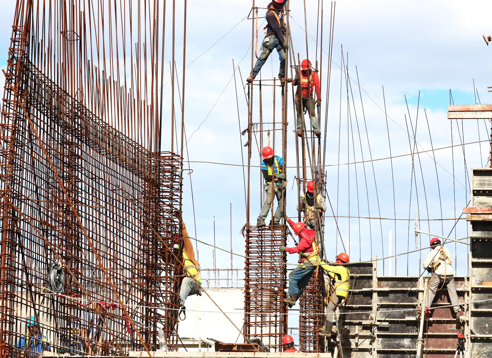 Workers on scaffolding erecting reinforcement for a concrete column