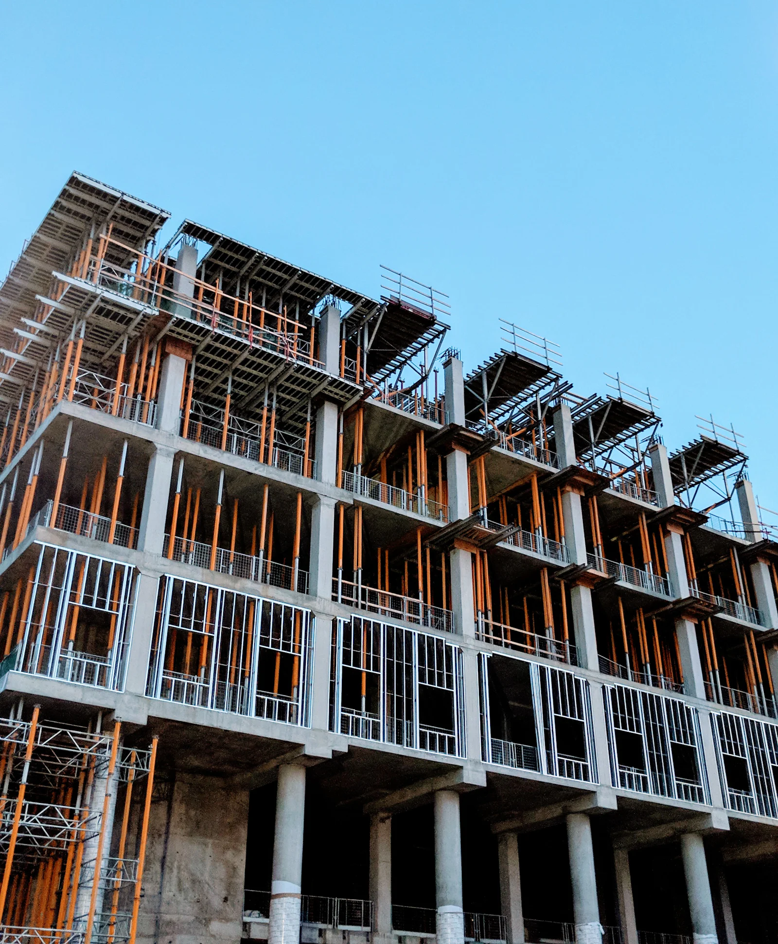 Multi-storey RCC building frame under construction against a clear sky